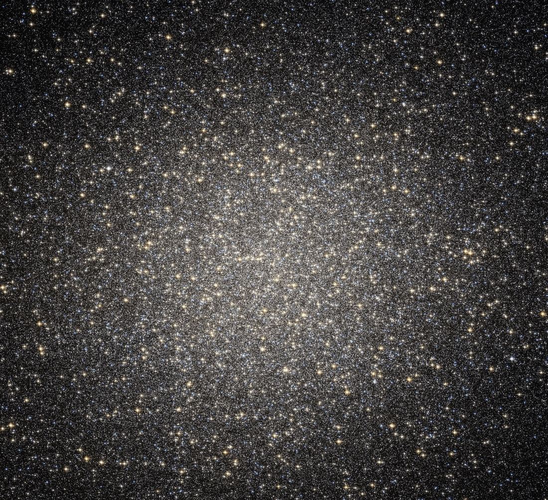 Campo muito denso de estrelas de cores variadas, do azul ao laranja e vermelho, sobre fundo escuro.