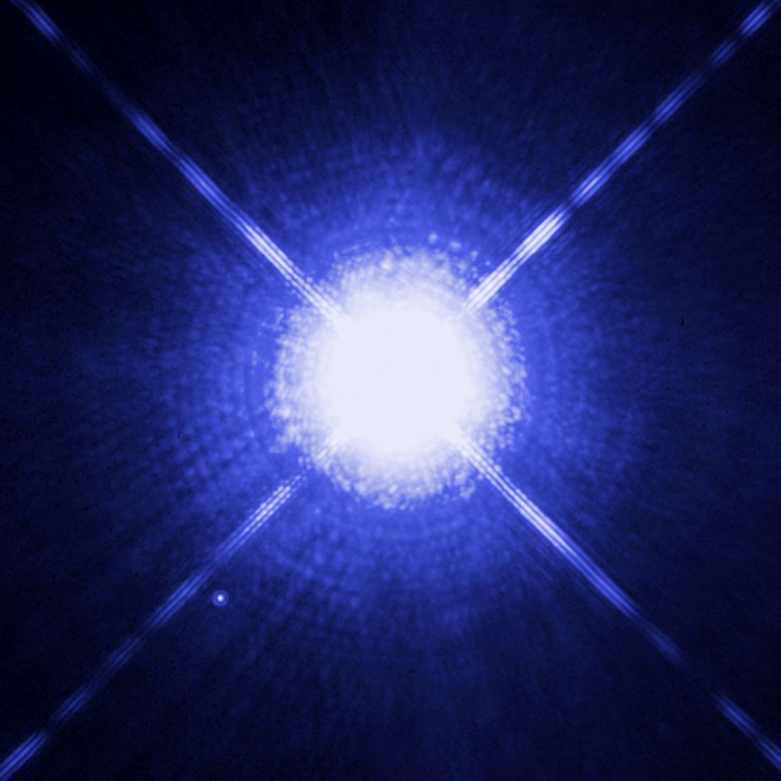 Estrela muito brilhante com picos de difração em cruz e um pequeno ponto de luz à esquerda e abaixo, Sirius B.